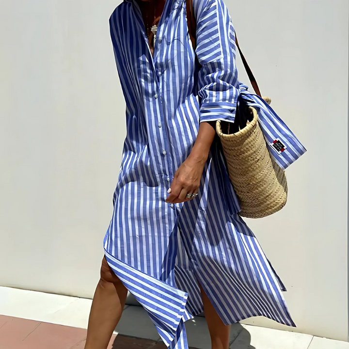 Close up, model wearing a blue and white striped shirt dress with a straw bag