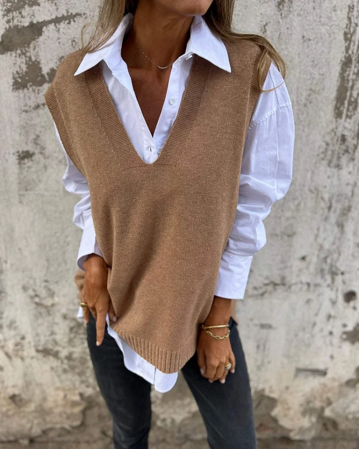Front view of a model wearing a brown V-neck cozy knit cardigan over a white shirt and dark jeans, with jewellery