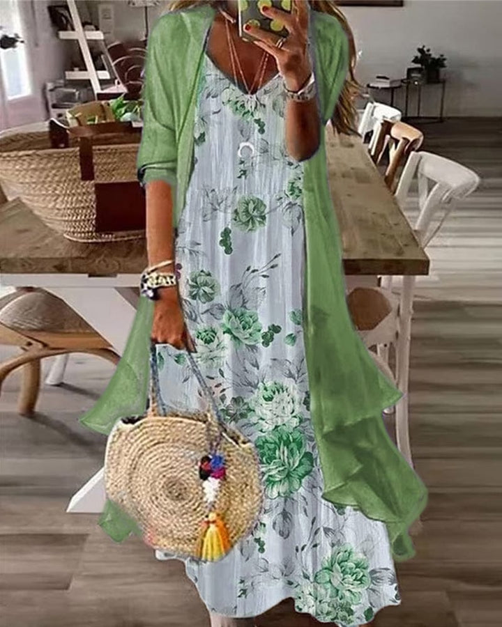 Front view, model wearing a floral draped 2-piece dress set with a green half sleeve cardigan and straw bag