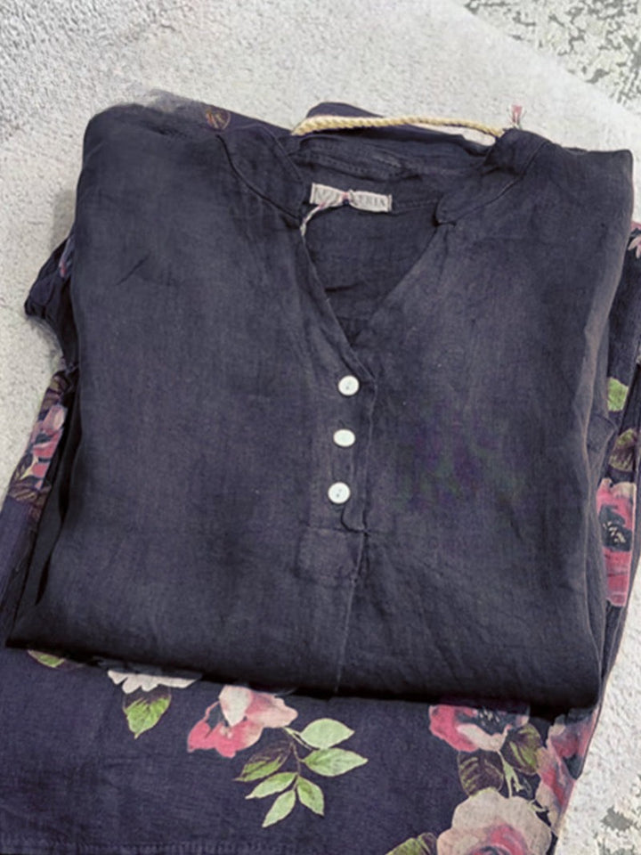 Flat lay of a folded dark blue cotton linen shirt with a floral pattern and white buttons