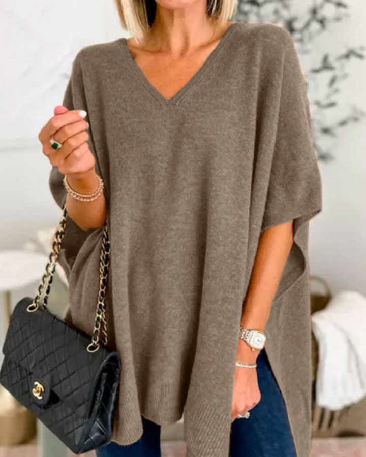 Front view of model wearing the Erica poncho sweater, showing the V-neckline and side splits