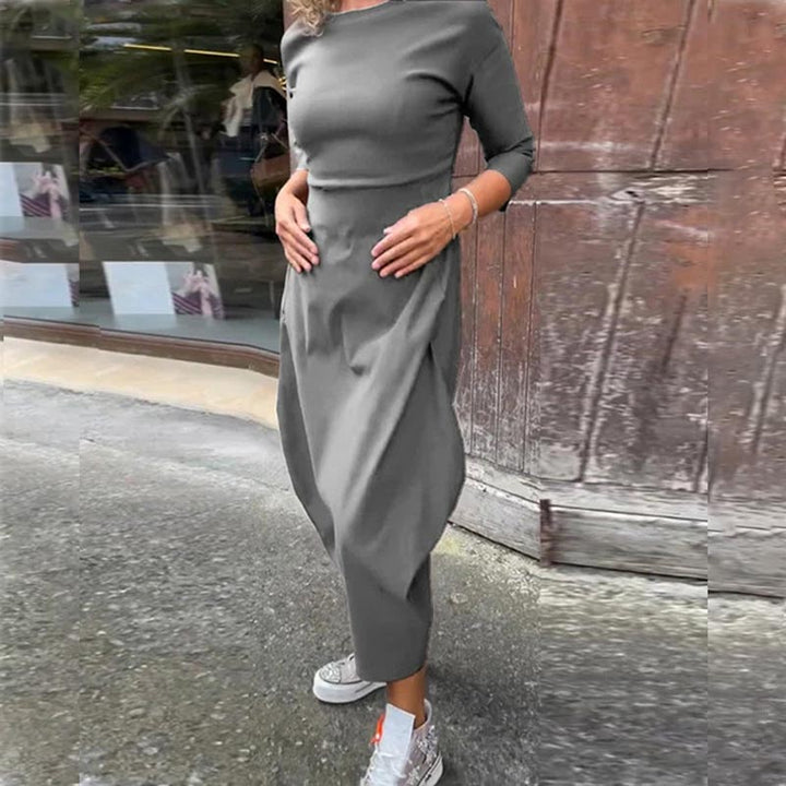 Three quarter view of a model wearing the Lana A-Line Dress in grey with hands on her hips