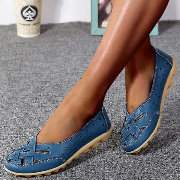 Worn by model, blue breathable leather loafers with woven toe and perforated sides on a grey carpet