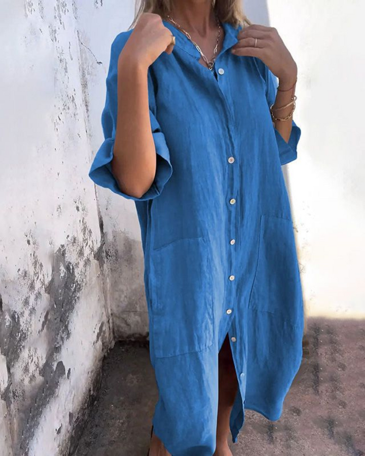 Front view of a model wearing a blue cotton casual midi dress with white buttons and two front pockets