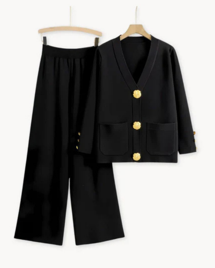 Flat lay of a black knitwear set, featuring a cardigan with gold buttons and wide leg trousers