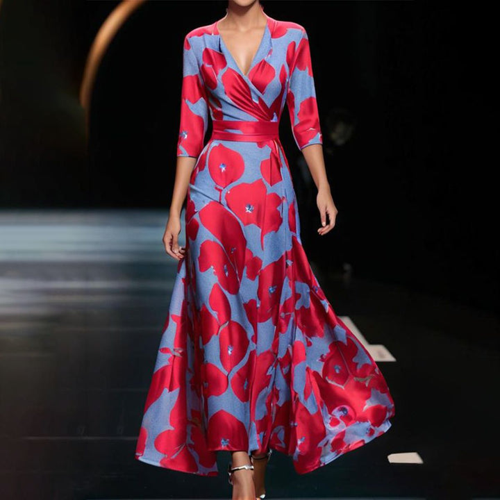 Front view of a model wearing a retro printed V-neck maxi dress with red flowers on a blue background