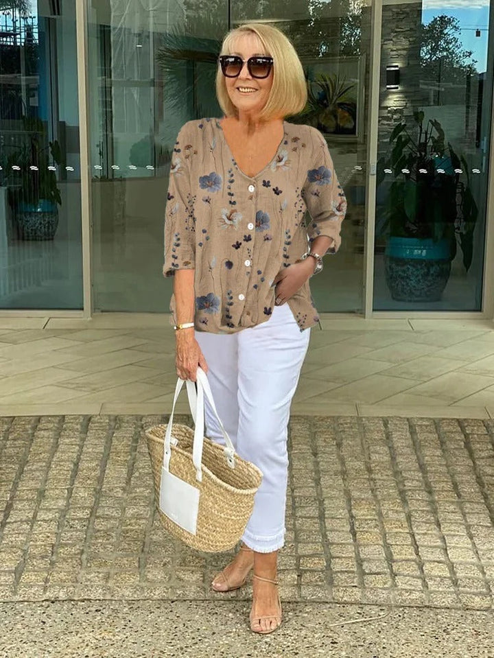 Mocha brown floral button up blouse with white capri trousers and sunglasses