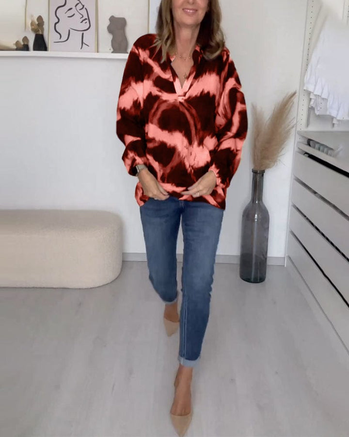 Red and pink printed V neck blouse worn untucked with jeans