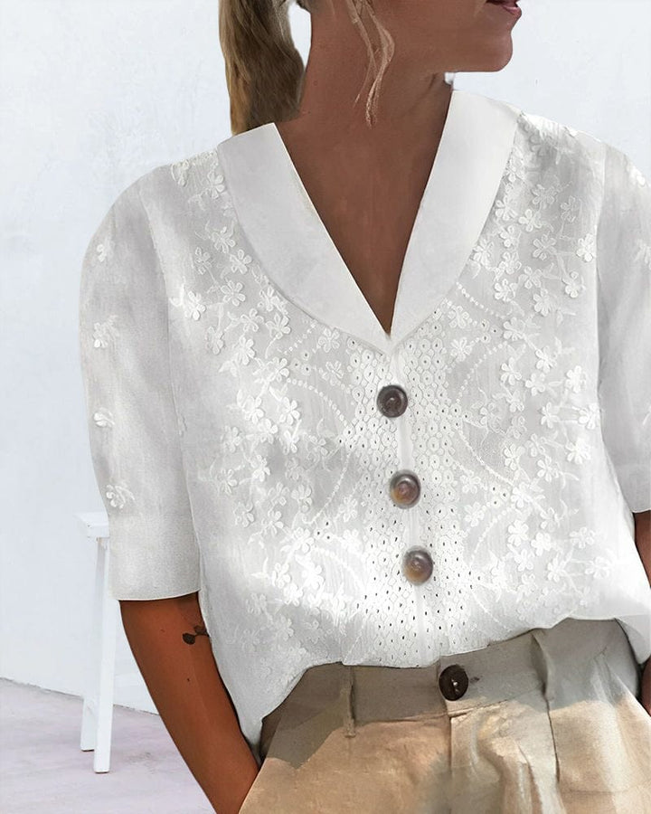 Close up worn by model, white floral cotton linen blouse with puff sleeves and brown buttons, angle from above