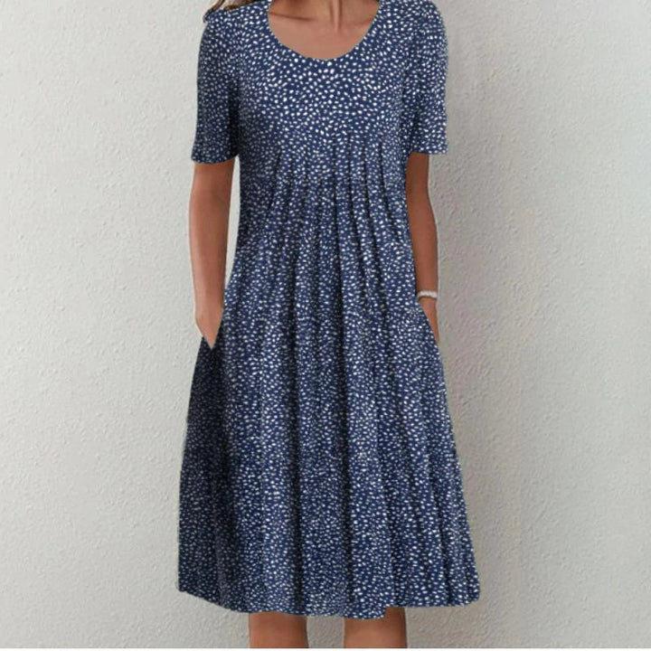 Front view of an elegant printed short-sleeved dress with a flared skirt and side pockets, worn by model