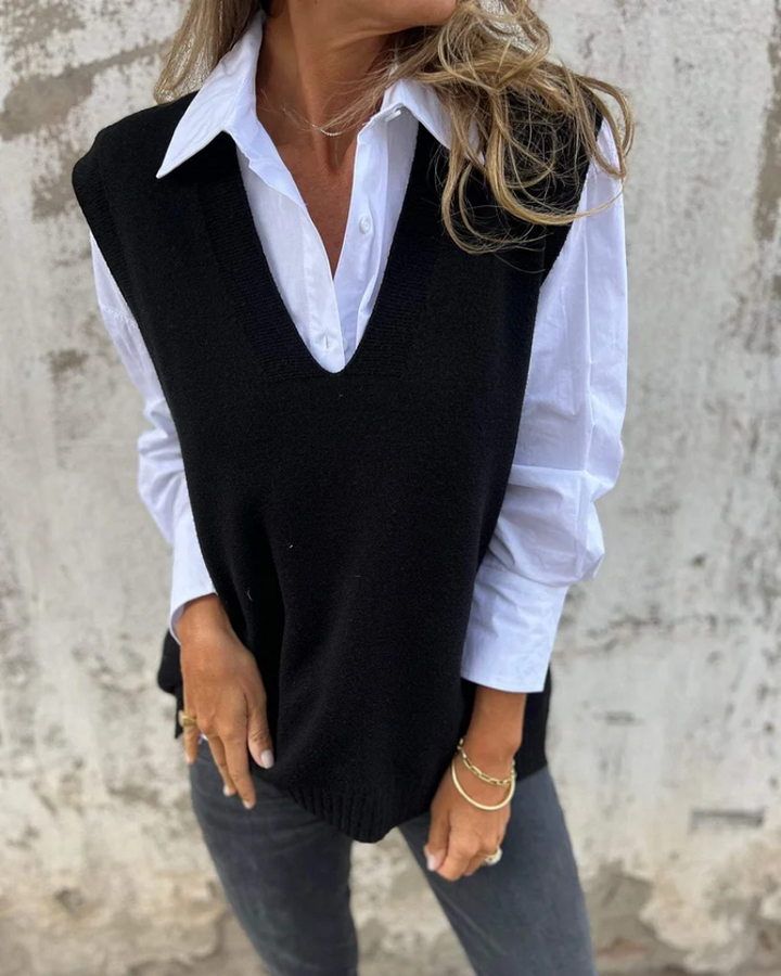 Front view of a model wearing a black V-neck cozy knit cardigan over a white shirt and dark jeans