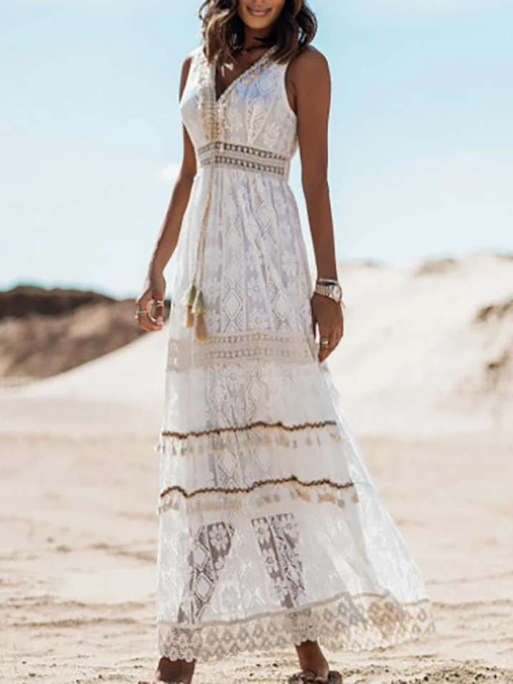 Front view of a model in a white Tassel V-Neck Pleated Maxi Dress with tassels on a sandy beach