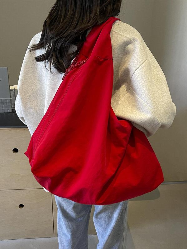 Back view, worn by model, of a red Lush Everyday Tote Bag over a grey sweatshirt and light blue jeans