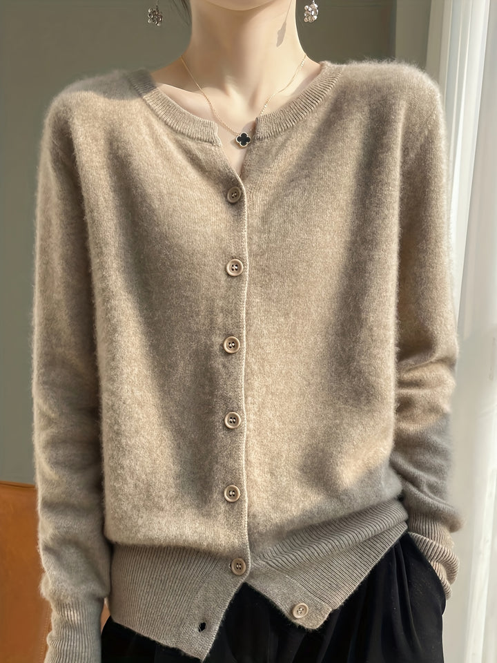 Close up of a model wearing the brown buttoned knit cardigan with a black clover necklace and drop earrings