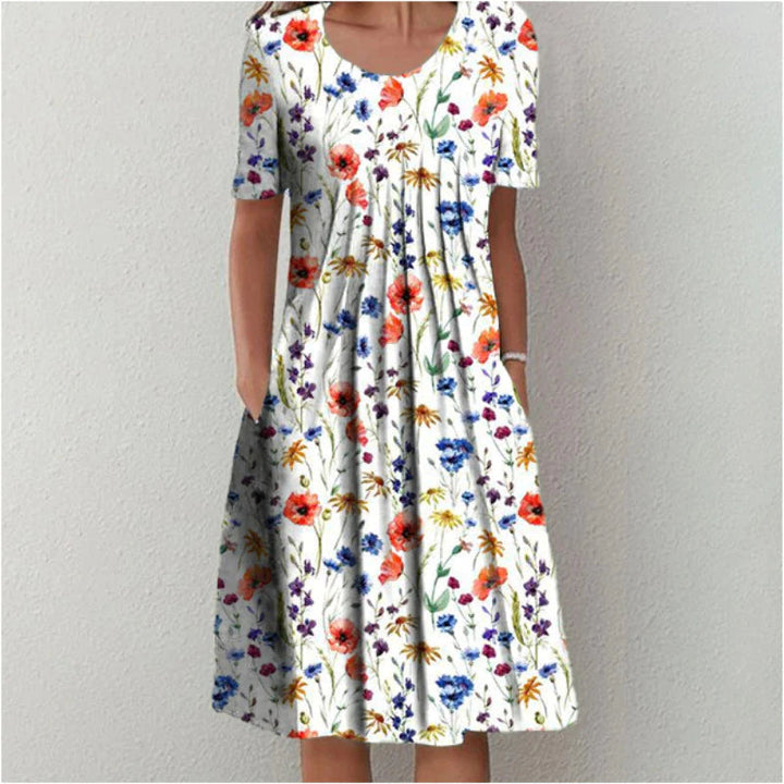 Front view of an elegant printed short-sleeved dress with a flared skirt and pockets, worn by model