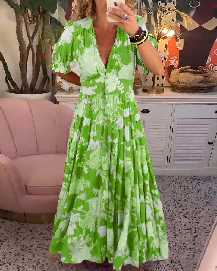 Front view of a model wearing a green floral summer dress with a deep V neckline and short puffed sleeves