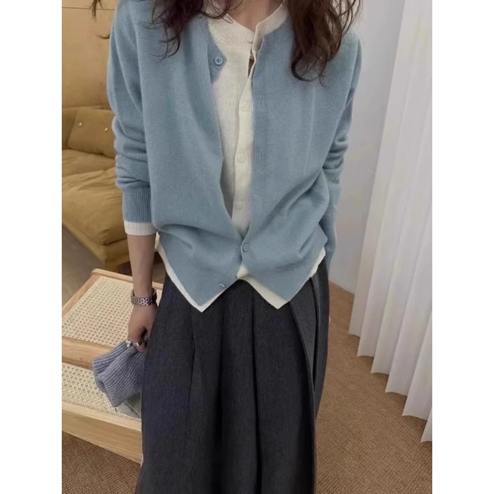 Front view worn by model, a light blue cashmere cardigan over a white top and dark grey skirt