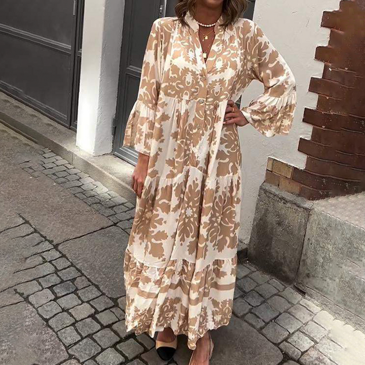 Front view of a model wearing a V-neck 3/4 sleeve maxi dress with a brown and white floral pattern