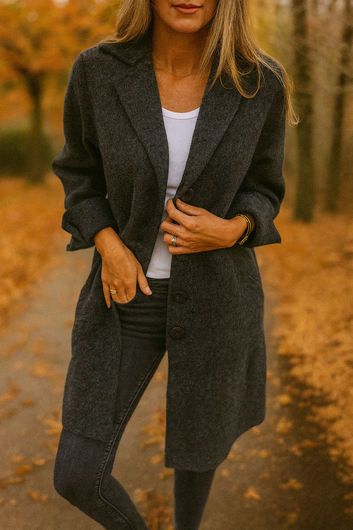 Front three quarter view of a model wearing the black Madison Elegant Mid-Season Jacket, unbuttoned, with hands in pockets