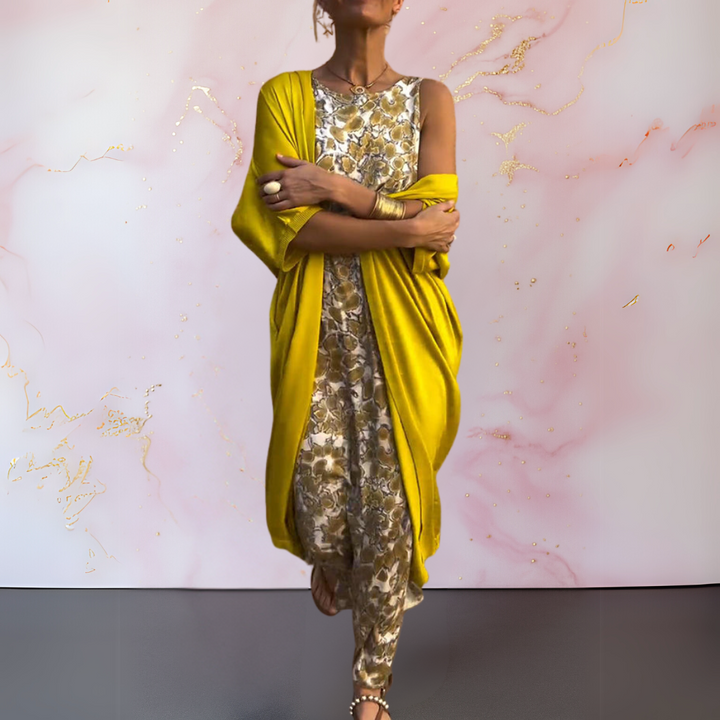 Front view of a model wearing a floral print boho maxi dress with a mustard yellow cardigan