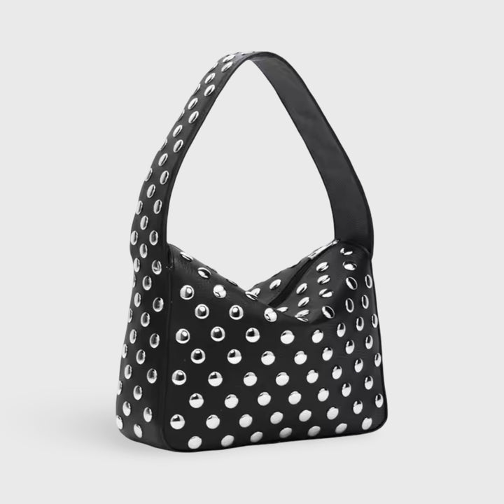 Front view of a black mini handbag with silver eyelets and a single shoulder strap
