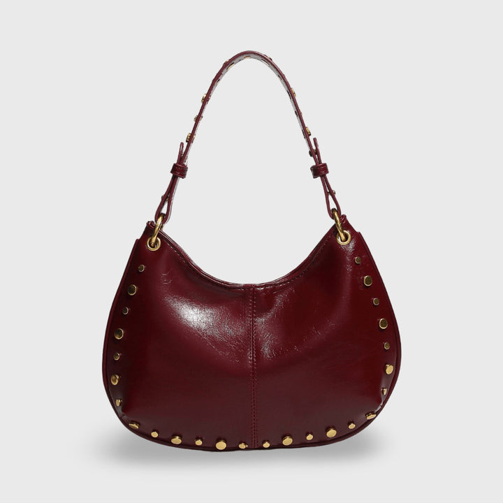 Front view of the mini handbag in burgundy vegan leather with gold studs and hardware
