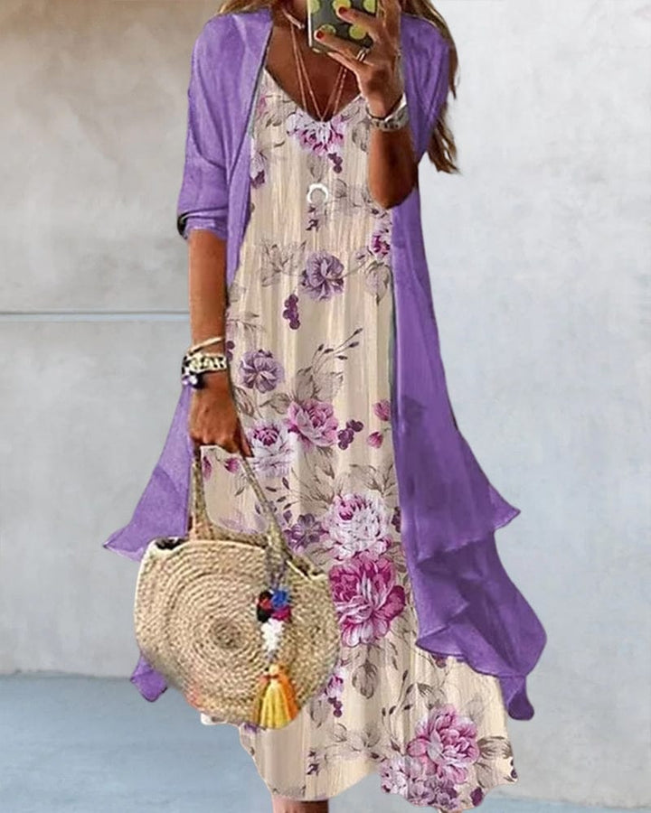 Front view, model wearing a floral draped 2-piece dress set with a purple half sleeve cardigan and holding a straw bag
