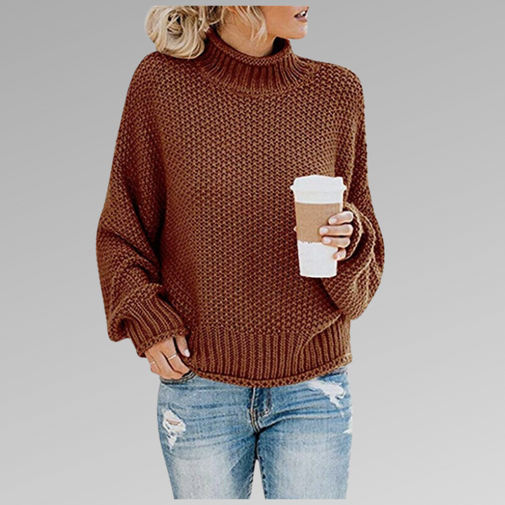 Front view of model wearing the brown Jovana Airy Touch Knit top with ripped jeans and holding a coffee cup