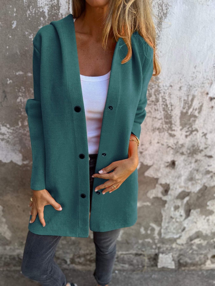 Teal hooded casual jacket with black buttons worn over a white top