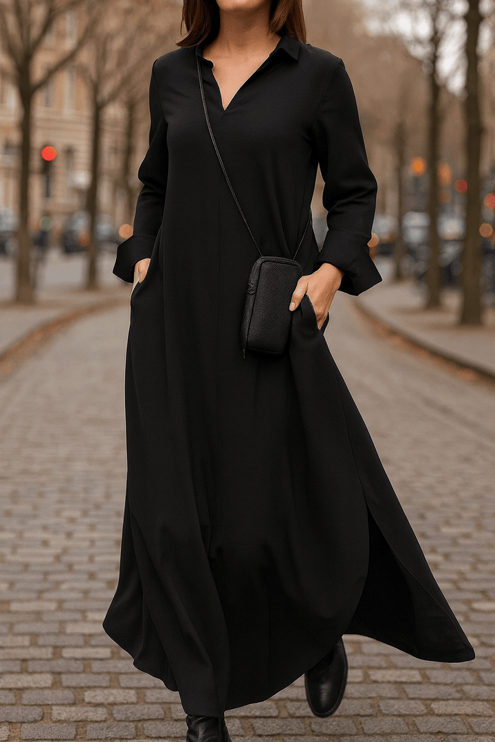 Front view worn by model of a black V neck oversized long dress with pockets and side splits