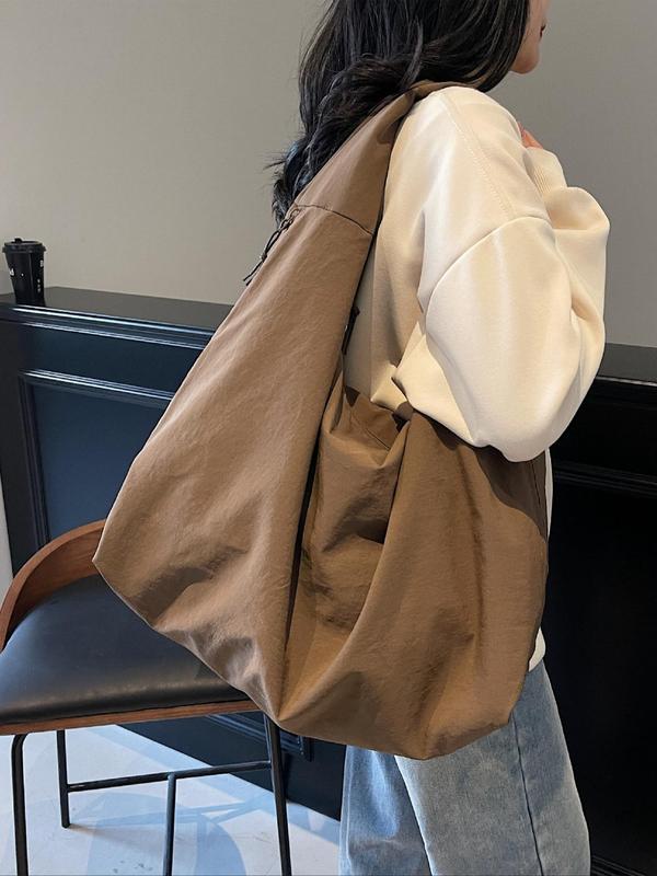 Side view, worn by model, of a brown Lush Everyday Tote Bag over a cream jumper and light blue jeans
