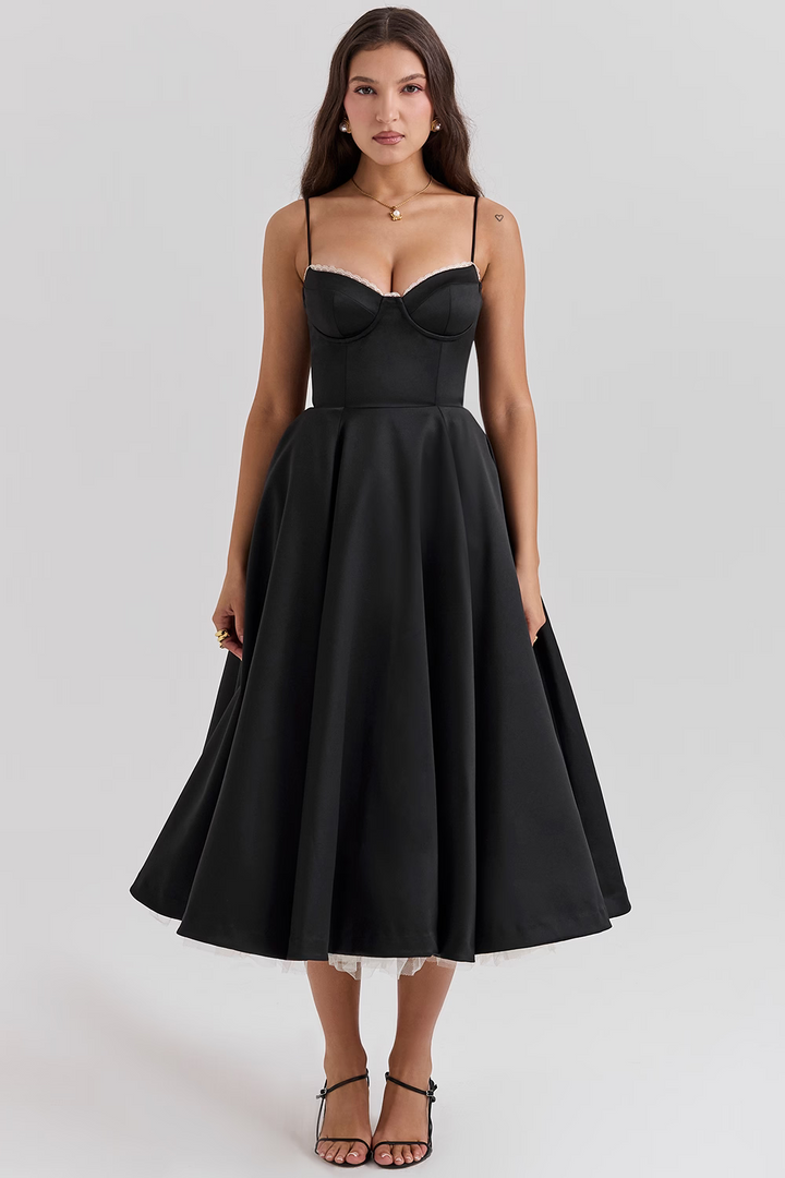 Front view worn by model, a black satin corset dress with white lace trim and a full midi skirt with a tulle underskirt