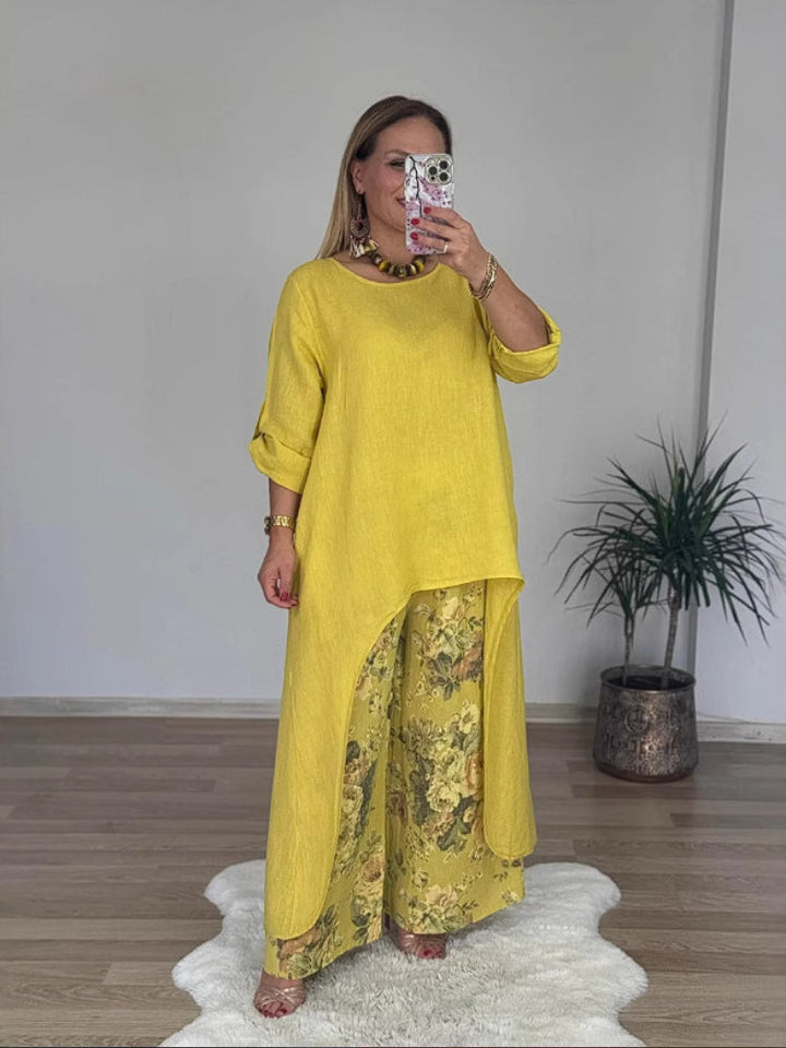 Front view of a model in a long-sleeve top and floral printed pants set, taking a mirror selfie, alternate angle