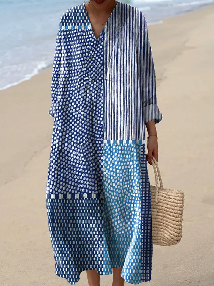 Front view of a model wearing a Marina boho dress with blue and white patterns on a beach