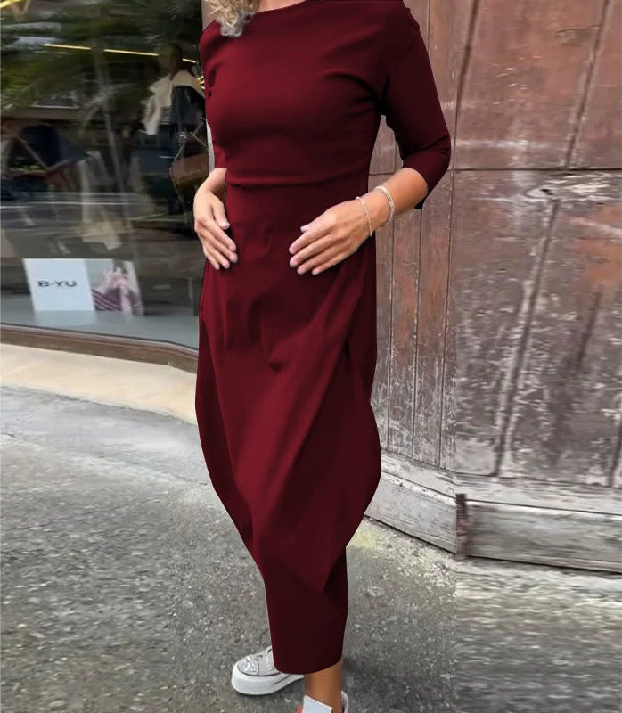 Front view of a model wearing the Lana A-Line Dress in dark red with hands on her stomach and white sneakers