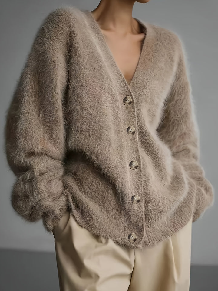 Front view, elegant knitted long-sleeve jacket in beige, worn by model with hands in pockets