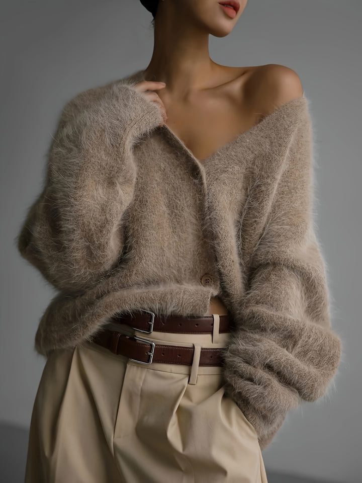Elegant knit V-neck cardigan worn by model, front view, one shoulder exposed, with beige trousers