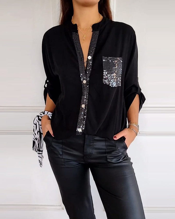Front view of a model wearing a black button blouse with sequined panels and a sequined chest pocket