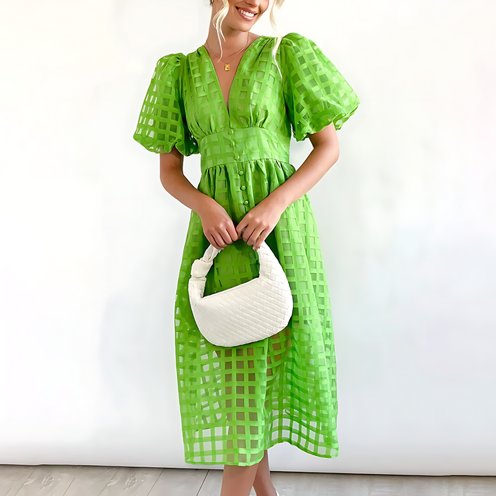Front view of a model wearing an elegant green summer midi dress with a white woven handbag