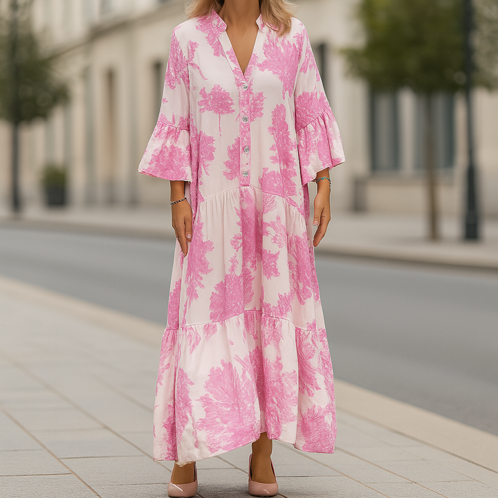 Front view of an elegant floral dress worn by model, a long pink and white cotton blend dress with tiered skirt