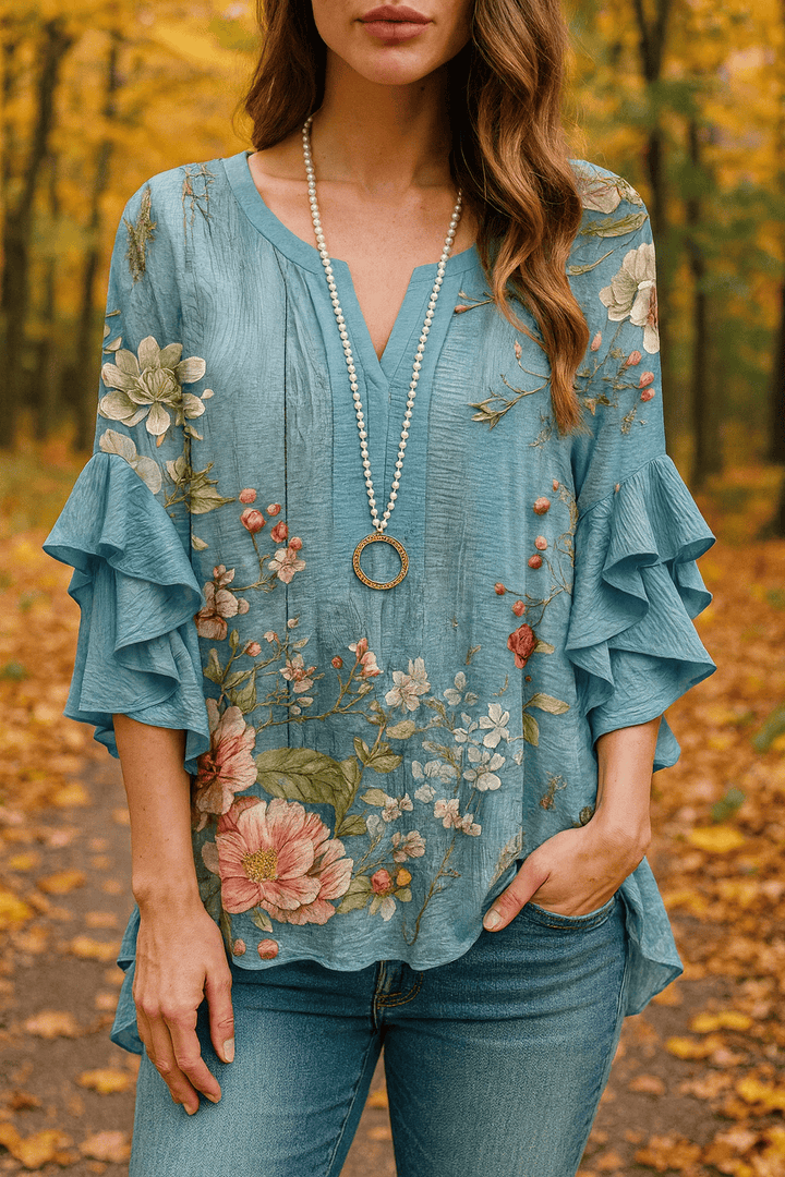 Front view of a model wearing the boho floral v-neck ruffle bell sleeve top with jeans in an autumn setting