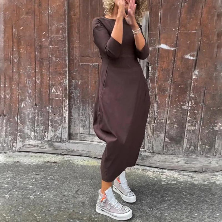 Front view of a model wearing the Lana A-Line Dress in dark brown with her hands covering her mouth