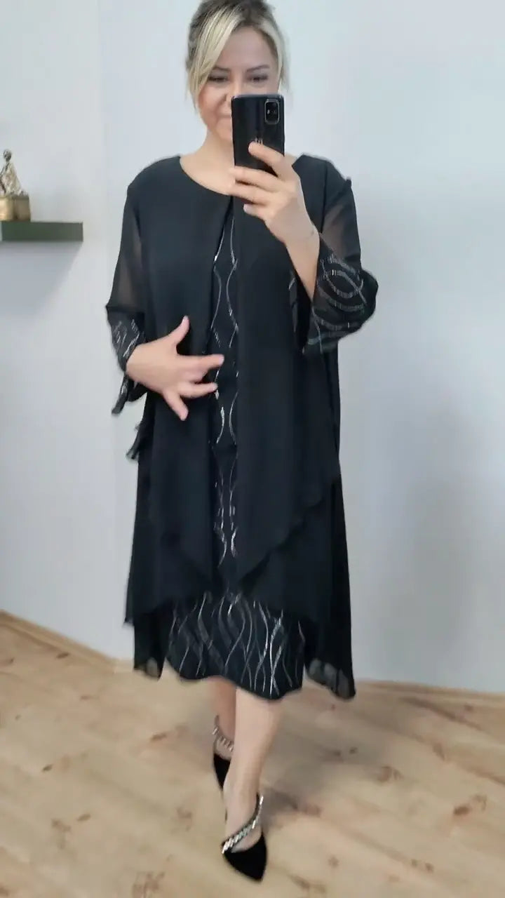 Front view of a blonde model wearing an elegant black chiffon ruffle midi dress with silver patterns
