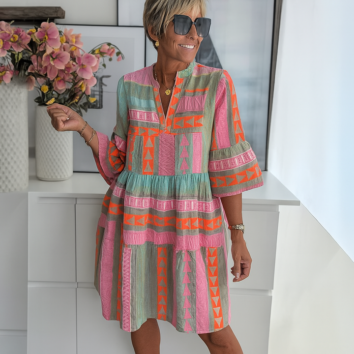 Front view of a woman wearing an autumn floral print V-neck dress with three-quarter sleeves