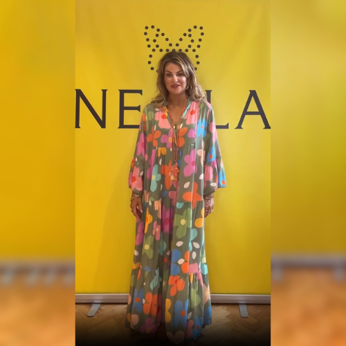 Front view of model wearing a long elegant floral dress in cotton linen blend with colourful flowers