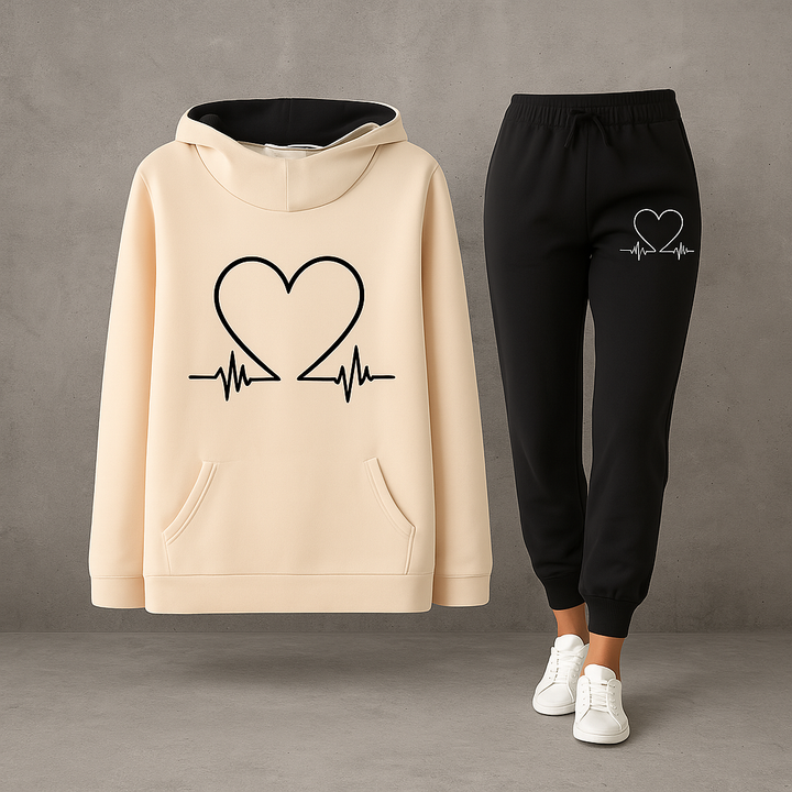 Front view, beige Heartbeat Tracksuit sweatshirt with black heart graphic and black joggers with white heart graphic