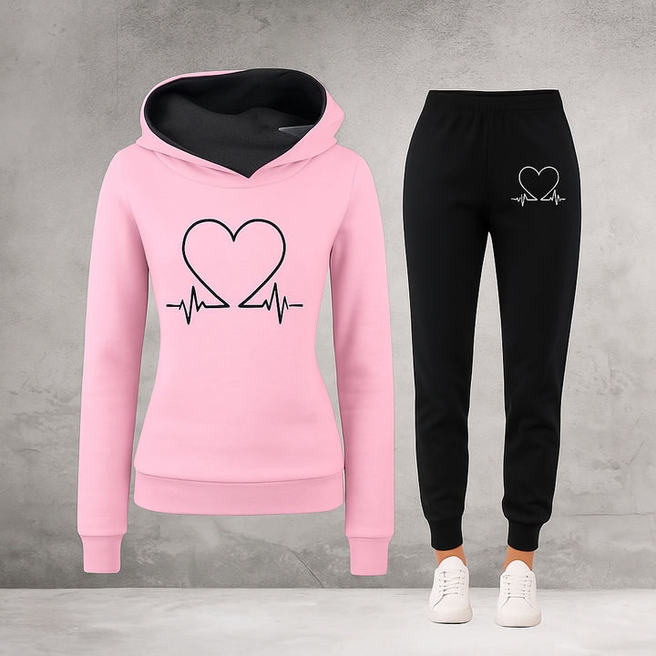 Front view, pink Heartbeat Tracksuit sweatshirt with black heart graphic and black joggers with white heart graphic