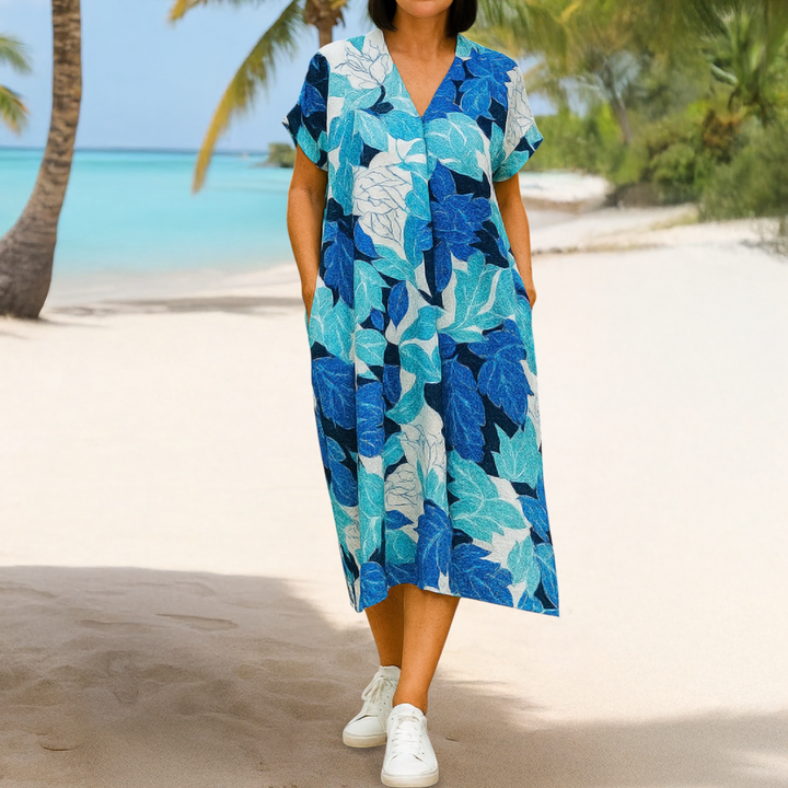Front view of a model in the Breezy Printed V-Neck Midi Dress with pockets on a tropical beach