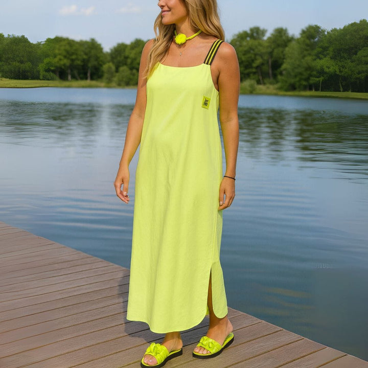 Side view of a model wearing a lime U-collar loose pullover ankle dress with side slits and pockets