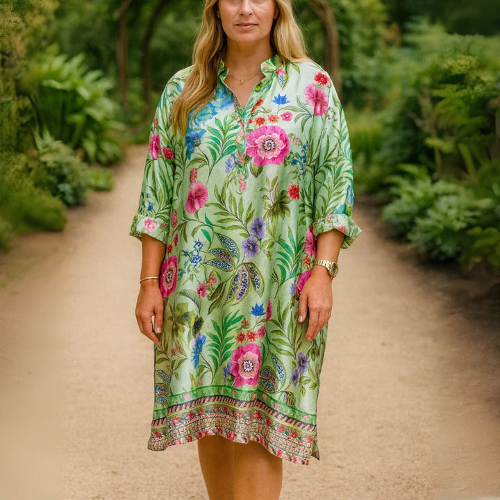 Front view, model wearing a loose floral midi dress in light green with pink and blue flowers